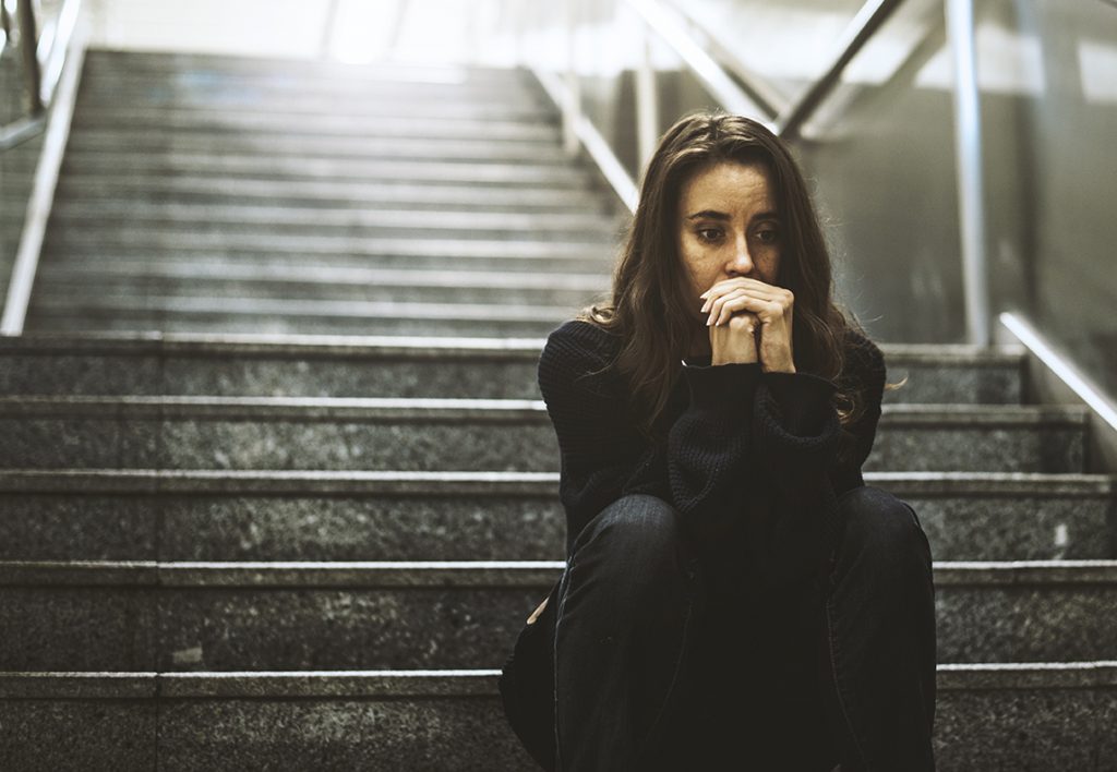 Mujer sentada mirada preocupada en la escalera